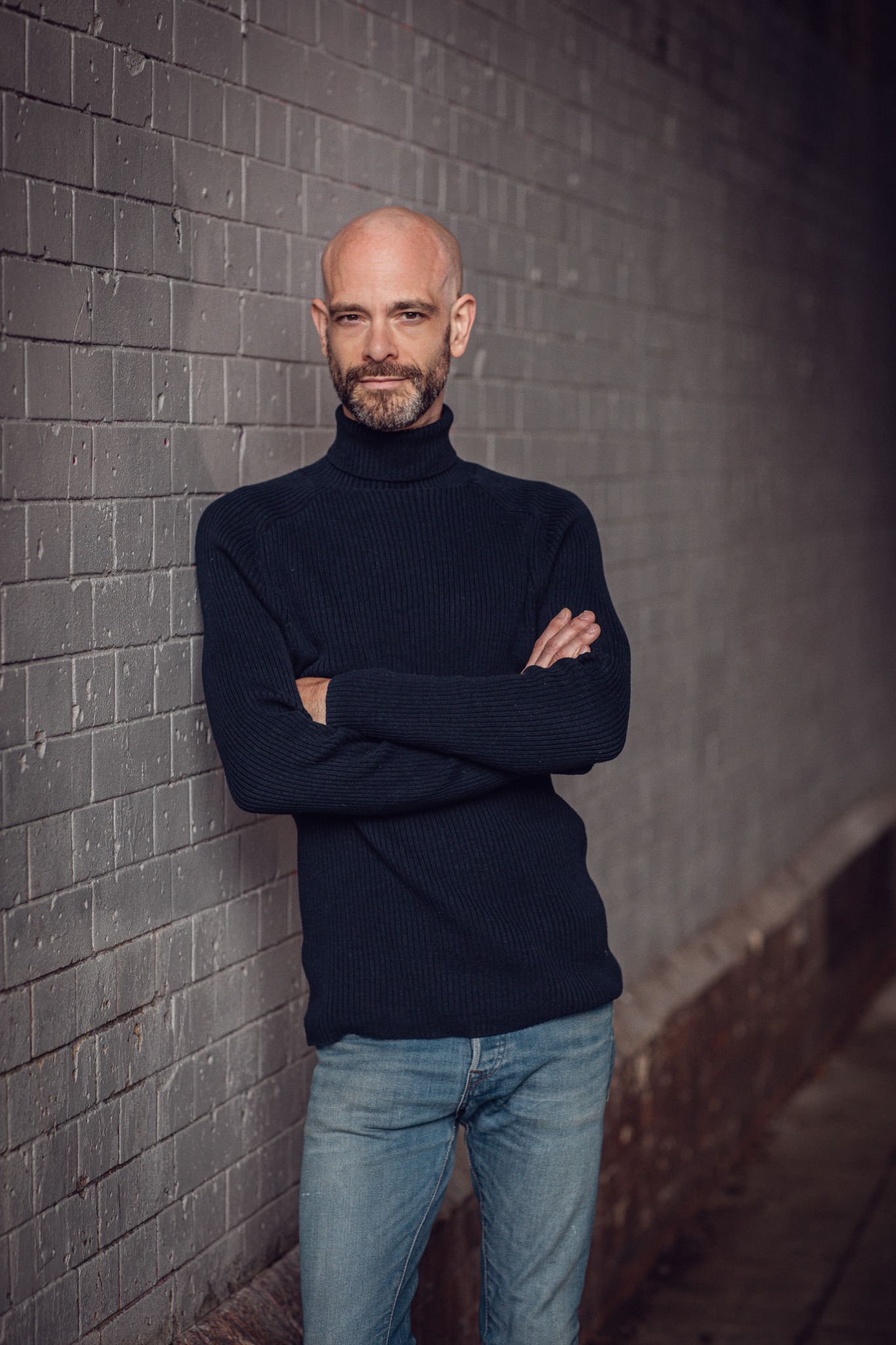 Peter Rae standing by a brick wall